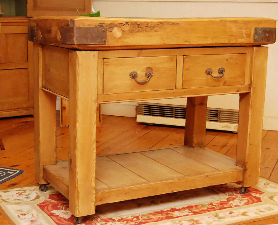 this husky authentic old butcher block from an English meat cutter ship has found a home on a reproduction base. It is the perfect marriage of old and new. The top has metal straps on all four corners. the base has been stained to compliment the