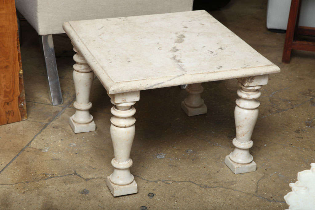 A white marble side table or bench with a square top.