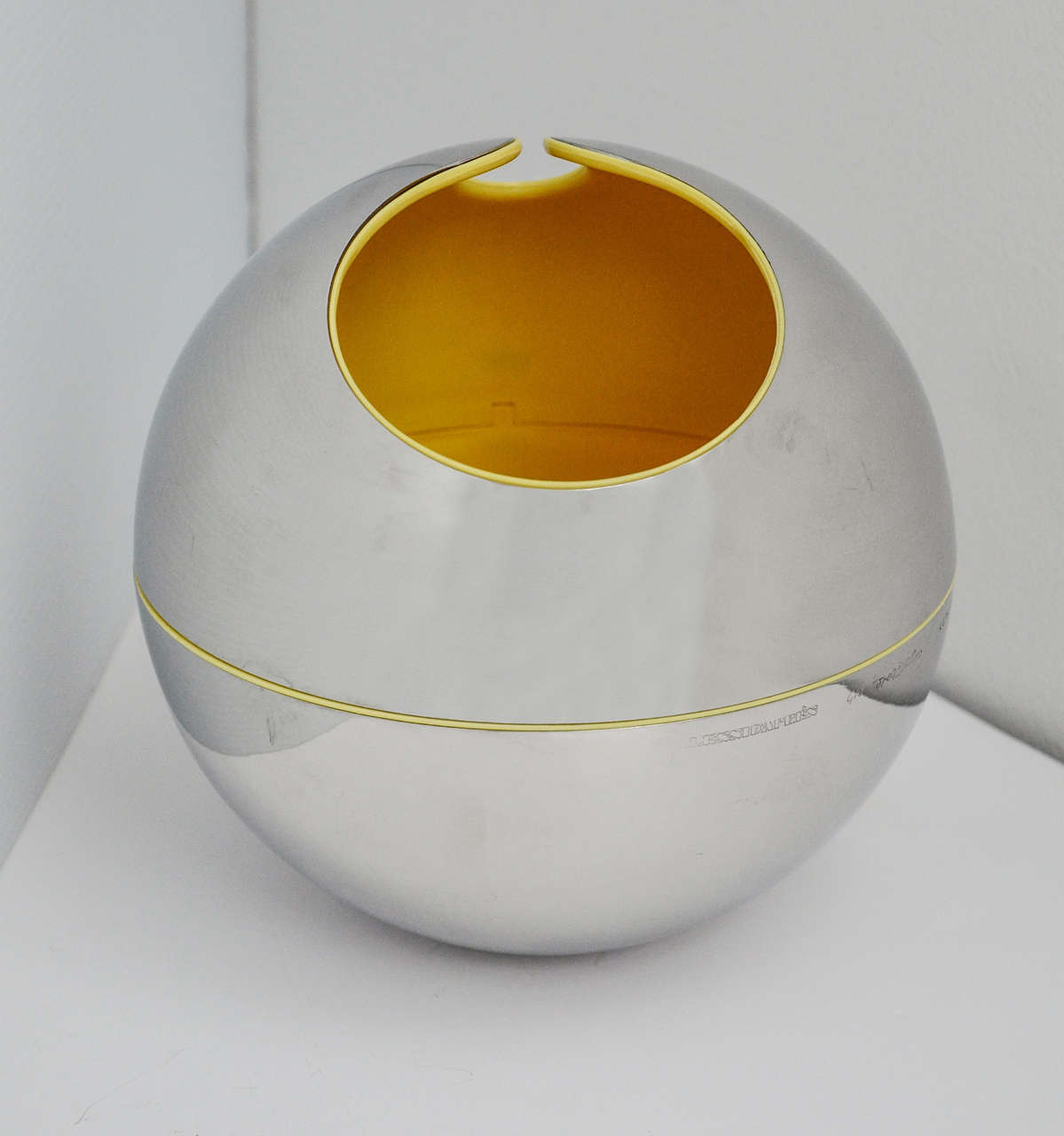 A stainless steel sphere with a yellow plastic interior designed by Gio Pomodoro for Alessi in 1972. Along with his brother Arnaldo
Pomodoro, Gio (1930-2002) was a highly regarded Italian avant-garde sculptor. Both also were acclaimed jewelry