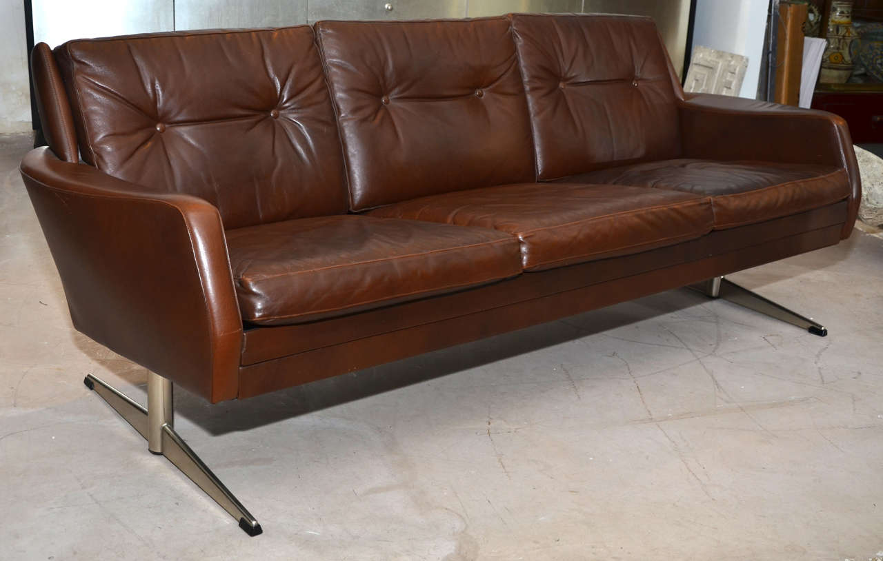 1970's danish brown leather sofa. Chrome steel feet. Normal wear consistent with age and use.