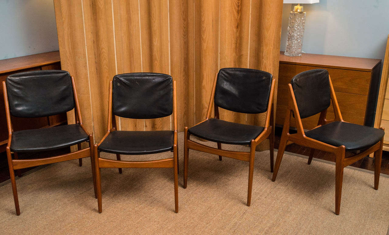 Original set of eight Arne Vodder design teak dining chairs with original black leatherette and pivoting back rests.