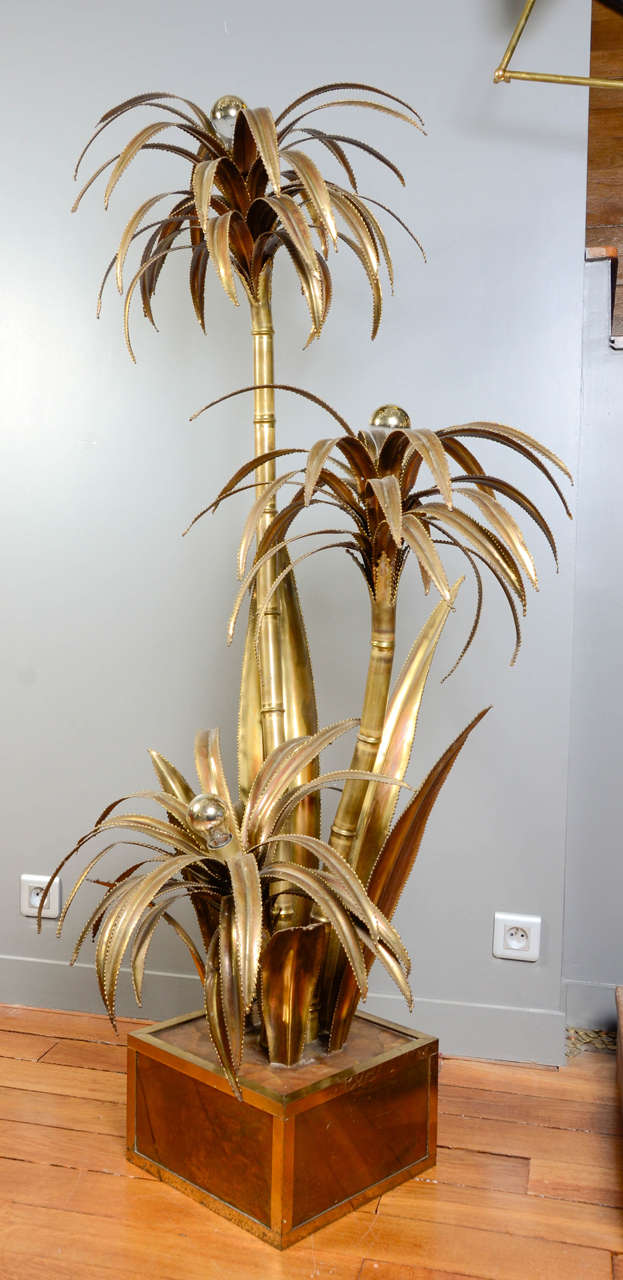 Famous palm trees floor lamp by Maison Jansen.
This piece is made of resin foot and three gilded metal palm trees and big leaves. In the center of the trees is hidden a bulb.
Typical French design from the 1970s, very decorative.