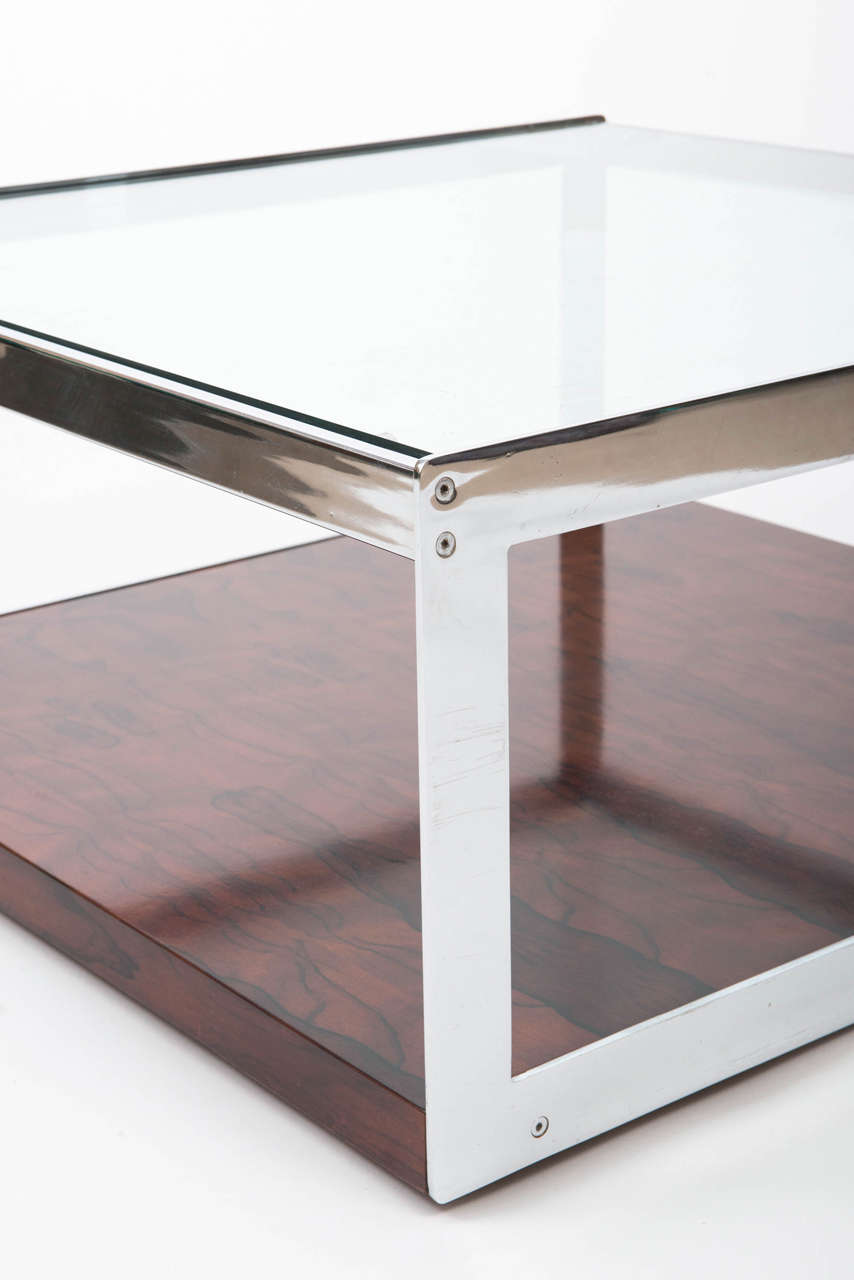 A Merrow and Associates rosewood coffee table of square form.
With inset square glass top set within a chrome frame. Above a rosewood veneered under tier.
England.
circa 1970.
Measures: 83.5 cms W x 86 cms D x 40 cms H.