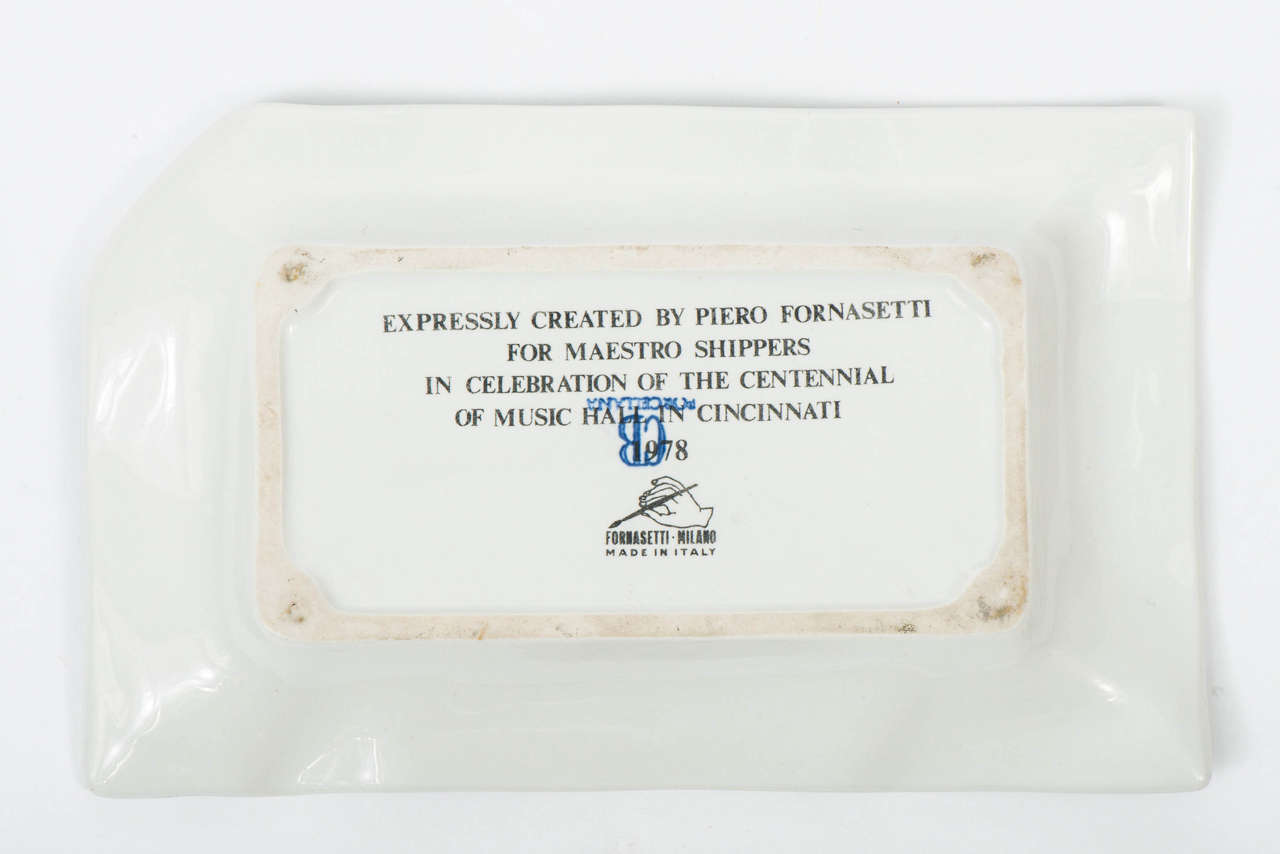 An ashtray by Piero Fornasetti, depicting the “Music Hall Cincinnati.”
Printed with an outside view of the Music Hall in Cincinnati.
Marked to back “expressly created by Piero Fornasetti for Maestro Shippers in celebration of the centennial of