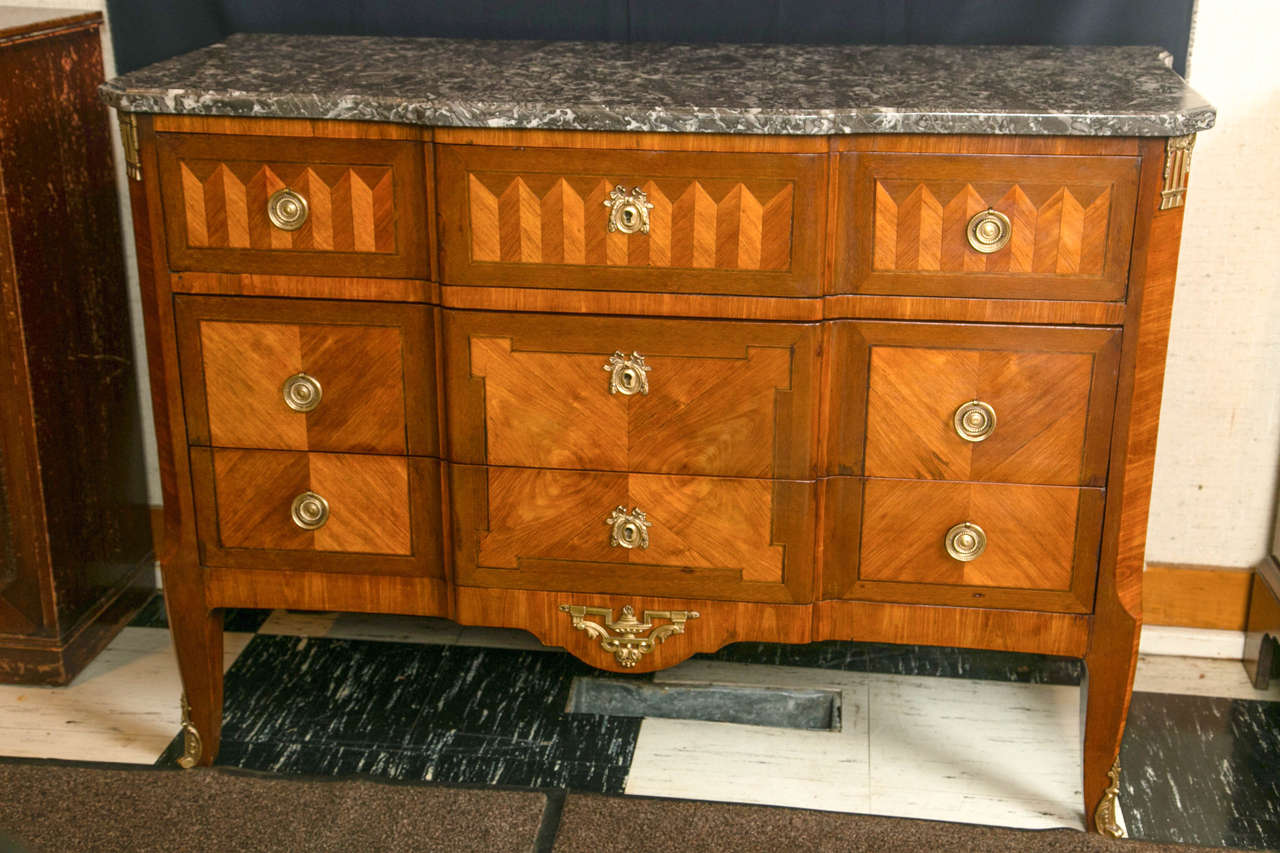 Remarkable parquetry inlay work defines this mahogany and kingwood commode. A beautifully mottled marble top, block front, and deeply chamfered front corners are welcome design elements that give this commode a handsome profile. With brass ring