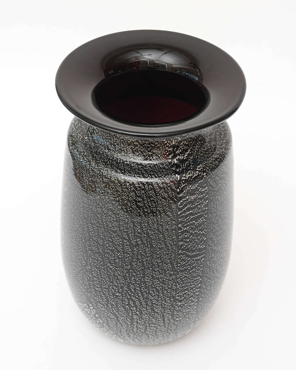 This stunning and substantial Murano vase by Seguso makes a statement all by itself without even any flowers in it!! The black glass is really amethyst glass with a purple hint inside.
The italian Maestro put abundance of random silver aventurine