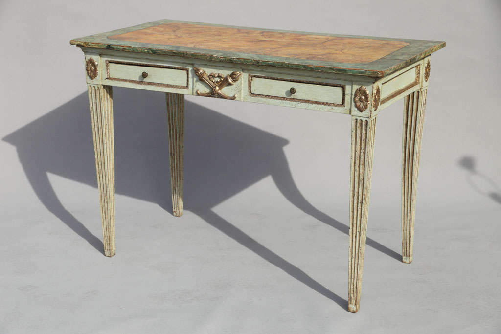 Painted Venetian console table, having a faux-painted rectangular top, on apron decorated with outcarved silvergilt crossed torches, flanked by double frieze fielded drawers; oval rosettes on each corner, raised on square tapered fluted legs.
