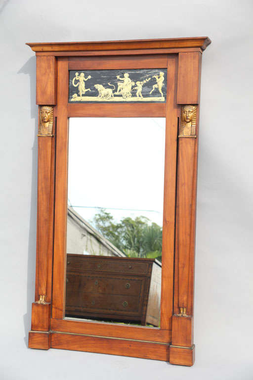 Regency mirror, of satinwood, in the Egyptian Revival period, having twin Egyptian caryatids flanking its rectangular mirrorplate, surmounted by pediment inset with églomisé panel painted with allegorical figures.

Stock ID: D5879