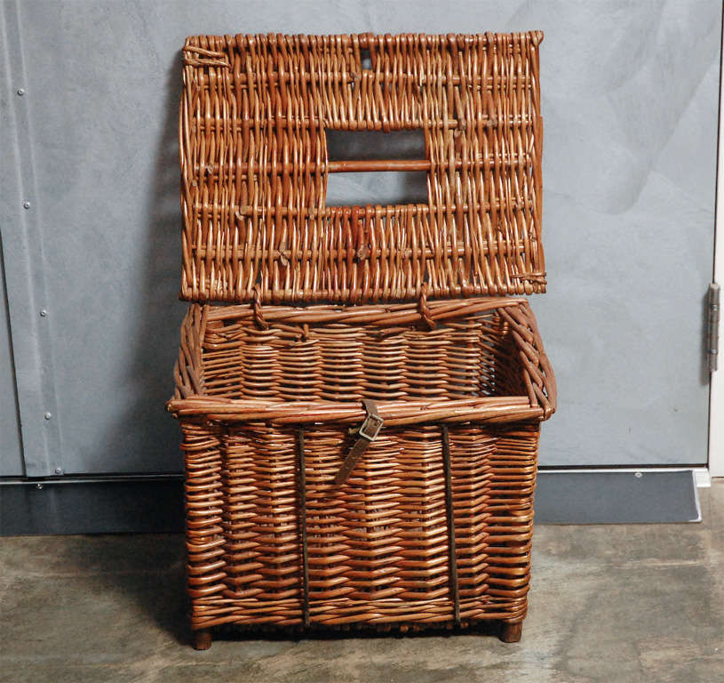 Woven in wicker, with an attached lid, resting on four legs. A basket will make a good accessory in lots of settings and be useful for things to be hidden away. This is the price for one basket. Jefferson West antiques offer a selection of antique