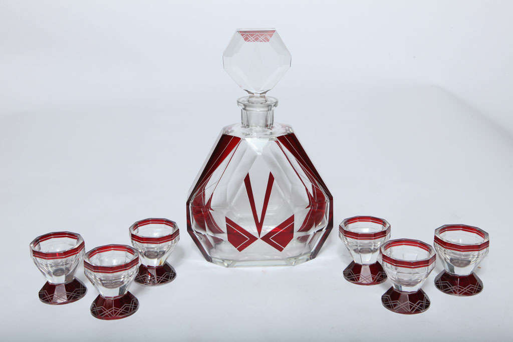 A beautiful example of 1930's modernist sophistication. The ruby red faceted set includes a decanter with six 2