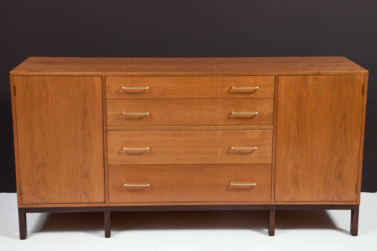 Light walnut body with brass handles for drawers resting on ebonized walnut legs. Exceptionally fresh and bright original finish throughout. Upper drawer has divided silverware section with silver cloth pads. Side compartments each have two