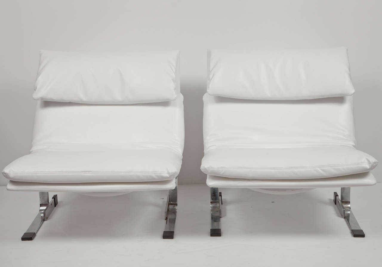 Two iconic Onda lounge chairs designed by Giovanni Offredi for Saporiti Italia; so marked; mirror-polished steel frames newly upholstered in white faux leather. Stamped with original maker's mark.

This pair of lounge chairs is on display on the