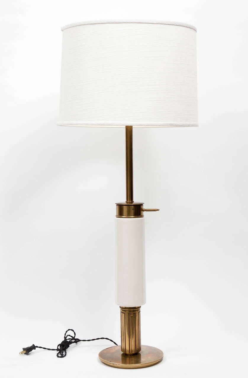 A modernist white porcelain and polished brass table lamp by Stiffel, USA, circa 1950. 

Features cylindrical porcelain body with circular brass base. Shade not included.
