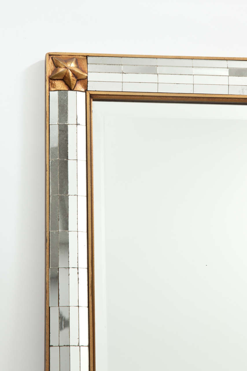 Fantastic 1940s French mirror in a gold washed frame with carved star motif on each corner. The beveled edge main looking glass framed by rectangular mirror pieces.
