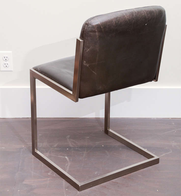 Set of four modernist steel and leather chairs, France, circa 1970. 

Clean, cantilever steel frame, sleek profile, and dark leather upholstery. 

 