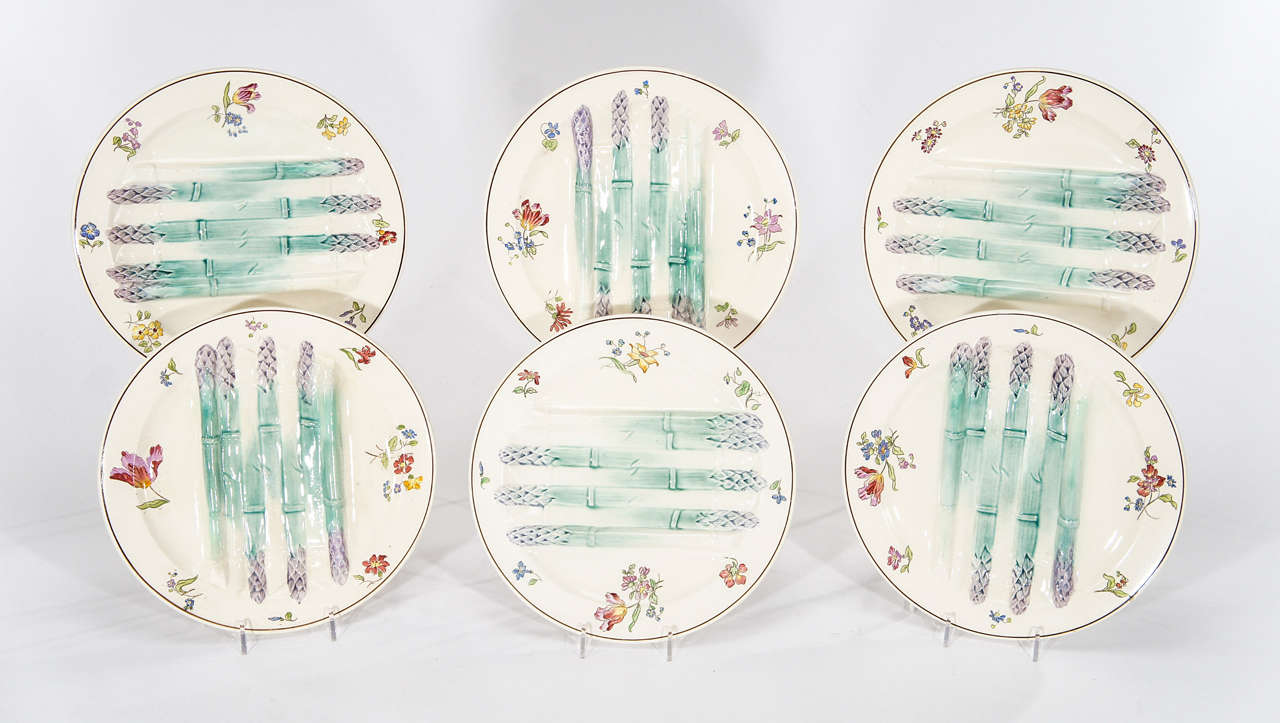 A charming set of 6 French Majolica/Barbotine large asparagus plates. Each one is uniquely painted and the set is perfect for display or use. The molded asparagus are raised and create a 2- dimensional effect. Each one is further embellished with