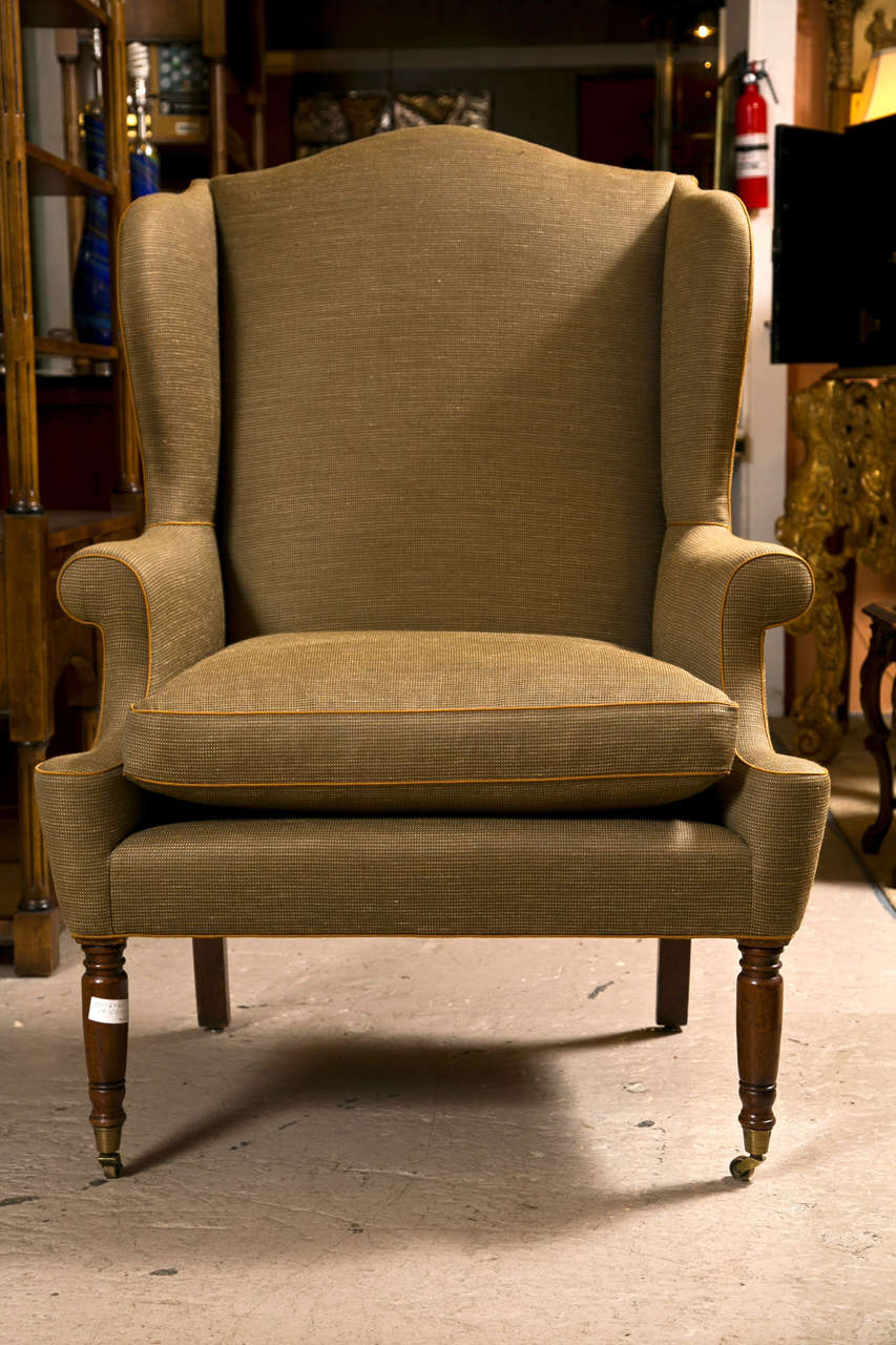  American walnut wingback chair, in a fine tweed upholstery, supported on turned front legs and splayed back legs. Signed back left leg.