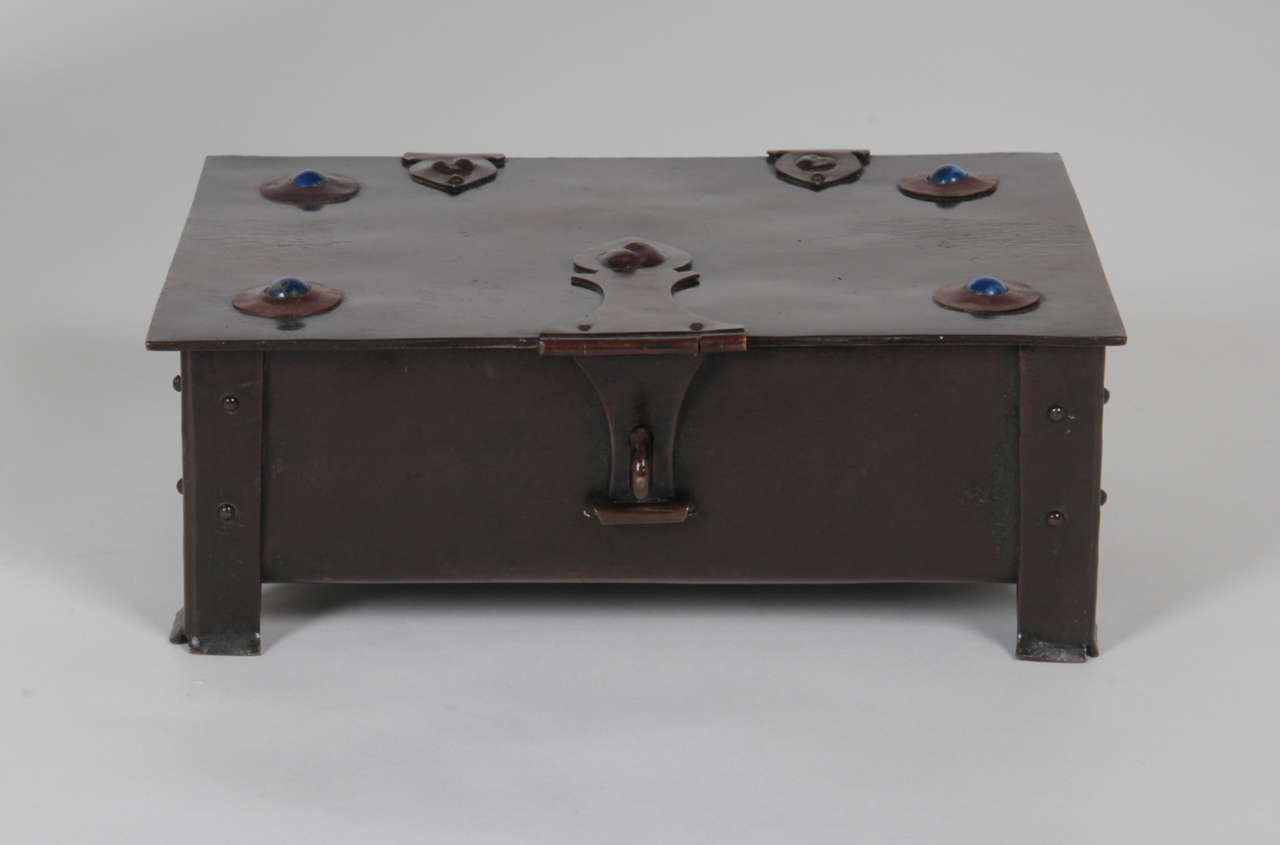 Albert Edward Jones (1879-1954)  Birmingham, UK
British Arts and Crafts Movement

Footed box with hinged lid and hasp   1905

Hand wrought and patinated copper with riveted strap work and hasp, inset with four cabochons of lapis lazuli, brown