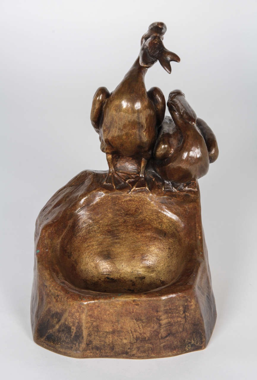 Friedrich Gornik  (1877-1943)  Austria.

“Pelicans”  vide poche   c. 1910.

Bronze with a natural gold patina of two pelicans on a rock, one seated and the other eating fish.

Marks: F Gornik and monogram.

For more information on Friedrich