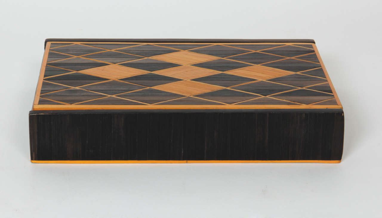 ANDRÉ ARBUS (attr.) (1903-1969) France

Straw marquetry box   c. 1940

Natural gold and ebony stained straw inlaid in a design of a window pane diamond pattern on the hinged lid, original suede cloth/paper interior, wood frame

For more