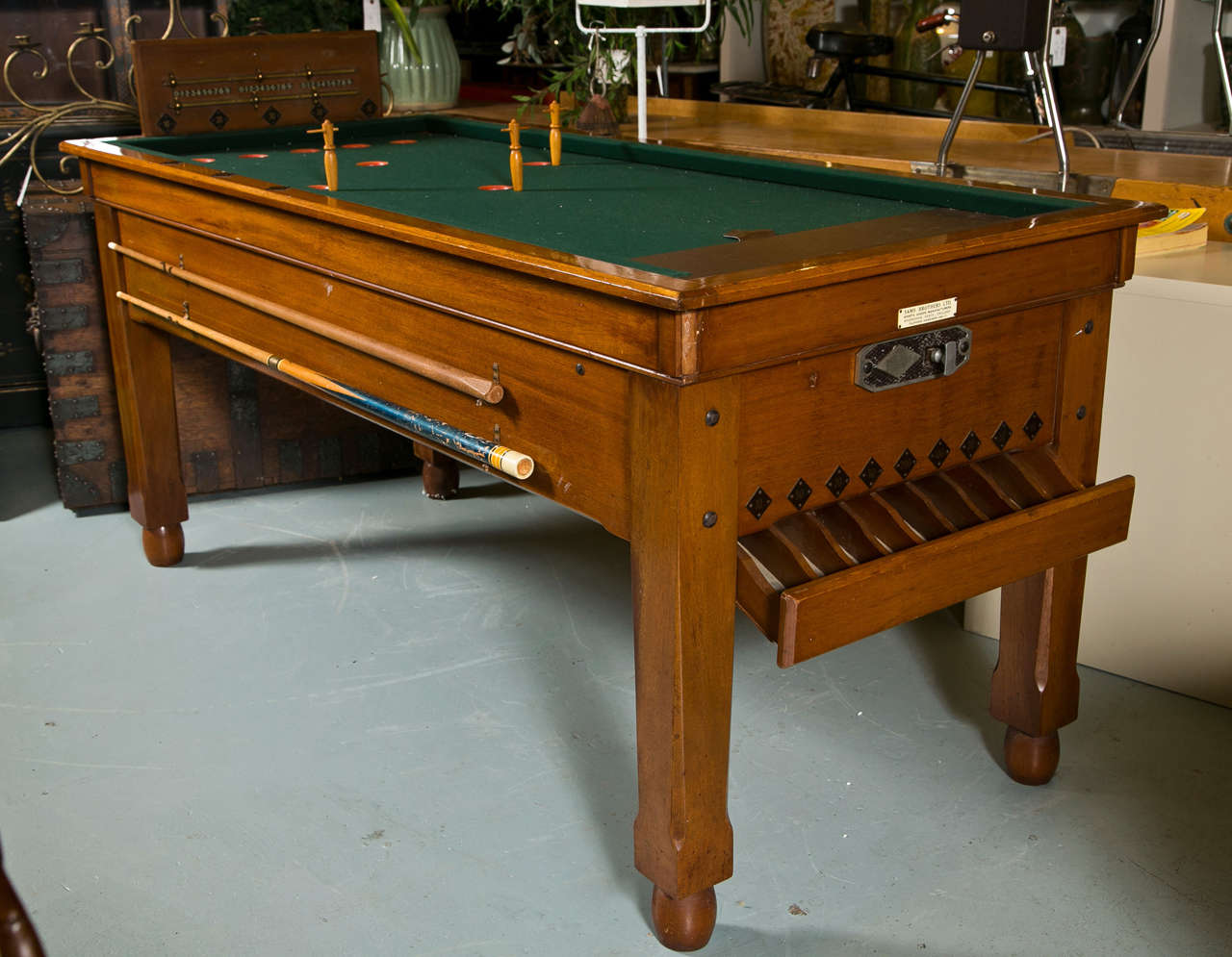 Coin operated English billiard table by Sam Brothers, Hoddesdon , England. Gill Jelkes convinced the English manufacturer to make a version of this game in bar size and was created in Oxford 1936.  They called the legs Jelkes (