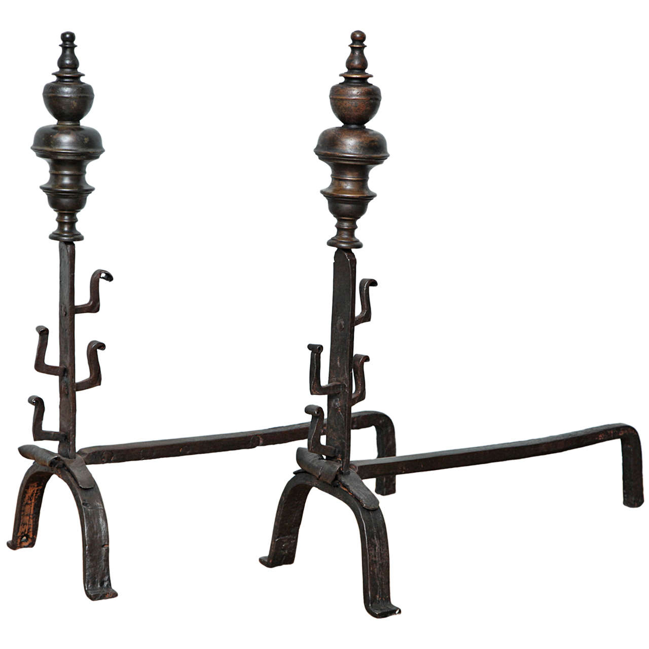 Fine pair of Northern European bronze and wrought iron andirons having unusually large finials over simple shafts having for and aft spit supports and standing on arched legs with simple square toes, both in excellent and unrestored condition, the