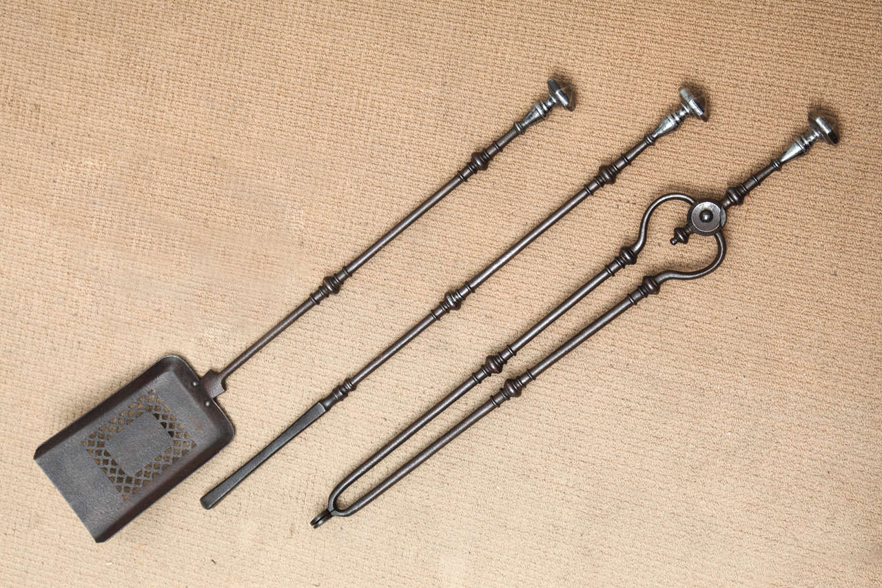 Fine quality set of three George III steel fire tools comprising a  shovel, poker and tongs, the bright polished handles with hexagonal faceted finials over patinated gun metal finish turned shafts with central turned bosses.. the square shovel with