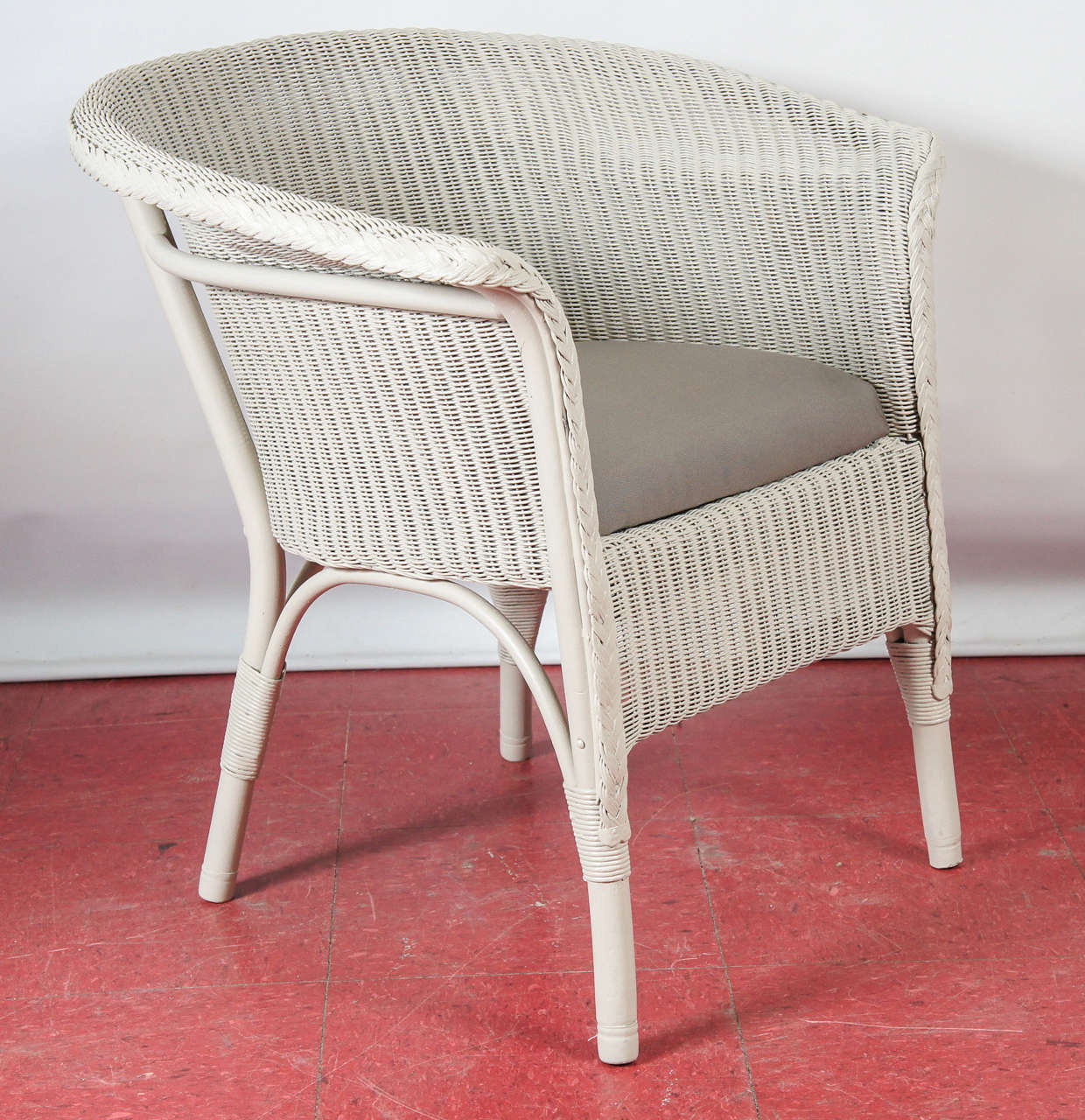 An original Lloyd Loom armchair. This looks like a wicker chair but the woven fabric is made of paper.  The material for these chairs and furniture was invented by Lloyd a 100 years ago associated with the Art Deco movement. The furniture is made