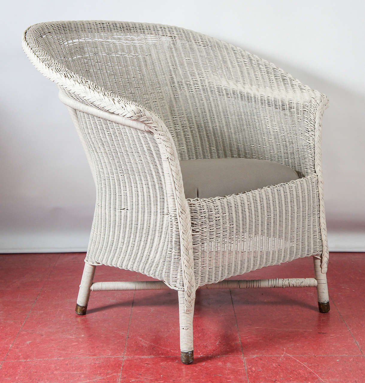 An original Lloyd Loom armchair. The material for these chairs and furniture was invented by Lloyd a 100 years ago associated with the Art Deco movement. The furniture is made using a unique process or twisted paper and wire on steam bent beach