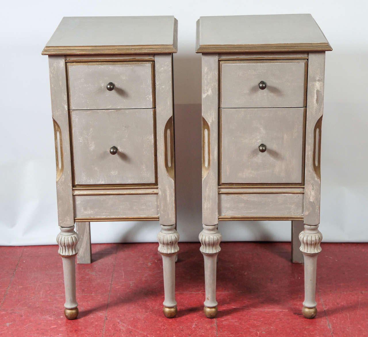 In the style of Swedish Gustavian or Louis XVI, these nightstands have generously deep dovetailed drawers with bronze pulls, and are painted French gray and trimmed in gilt.