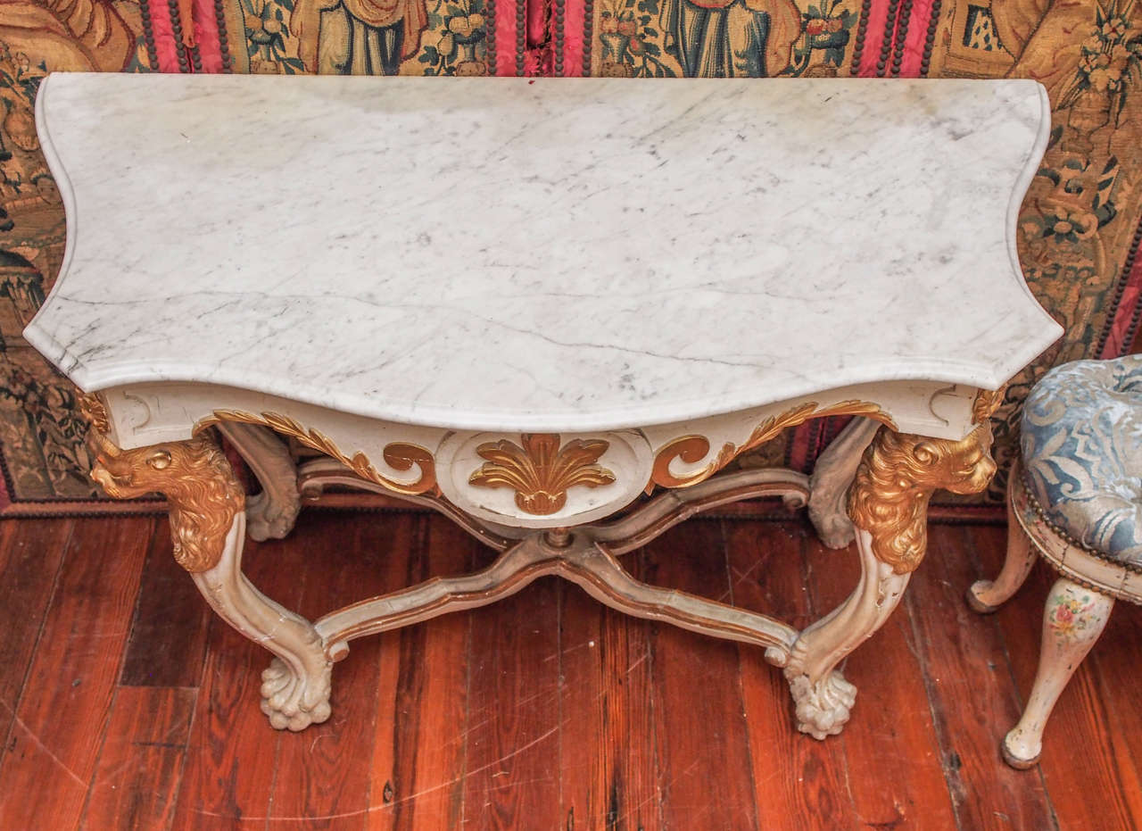 19th century painted and parcel gilt marble-topped console table with monopodial lions as legs connected by a crossed stretcher and a finial. This console is either Spanish or Italian.