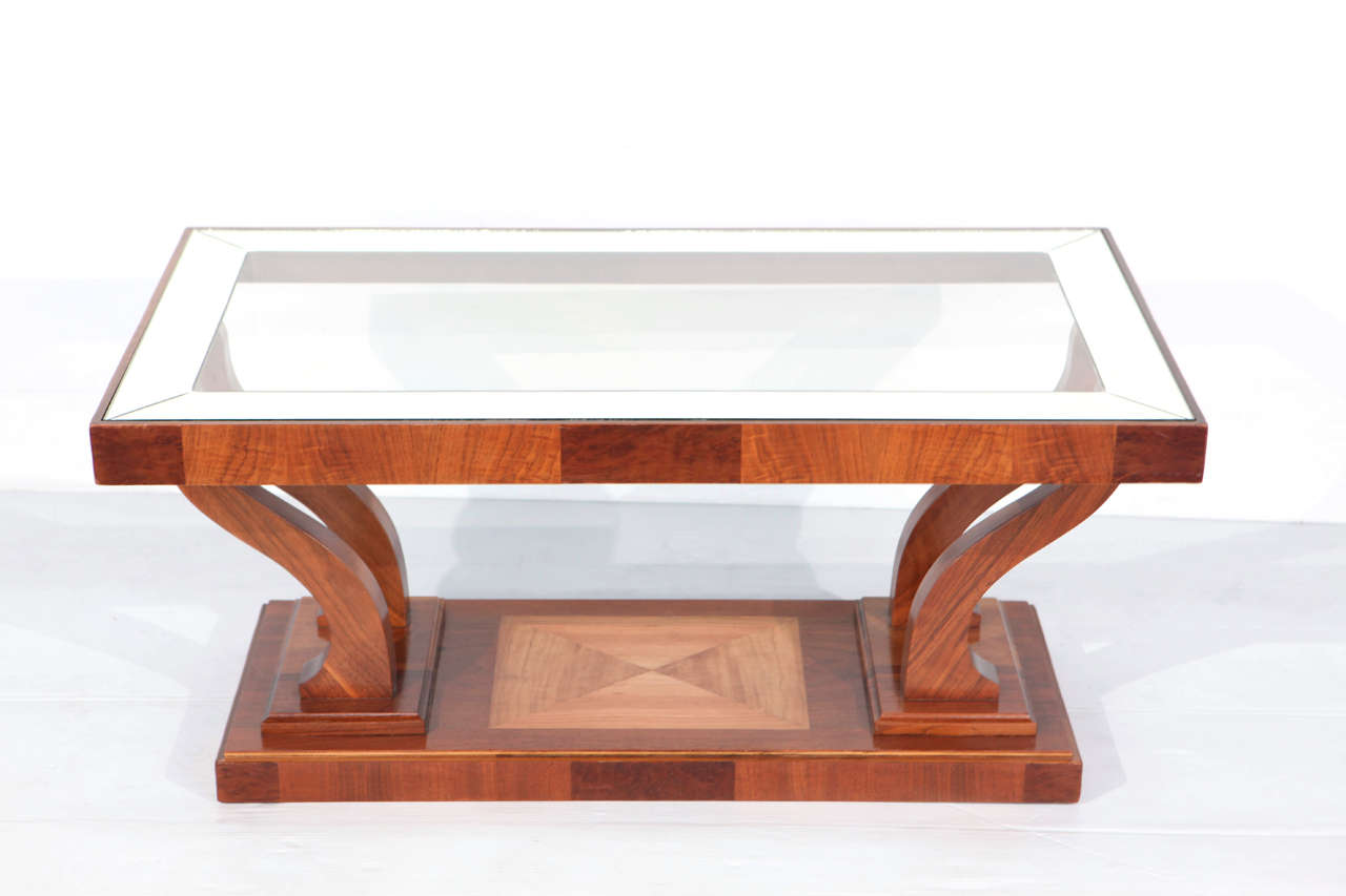 This beautiful art deco coffee table has a lovely glass top and is made with European walnut and maple wood.