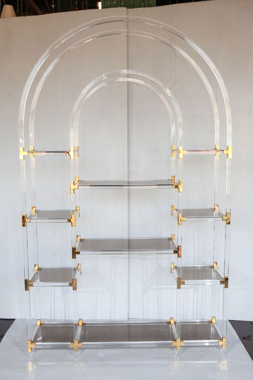 This clear lucite etagere is beautifully paired with smoky lucite panels. The gold platted metal also adds great detail to the etagere.