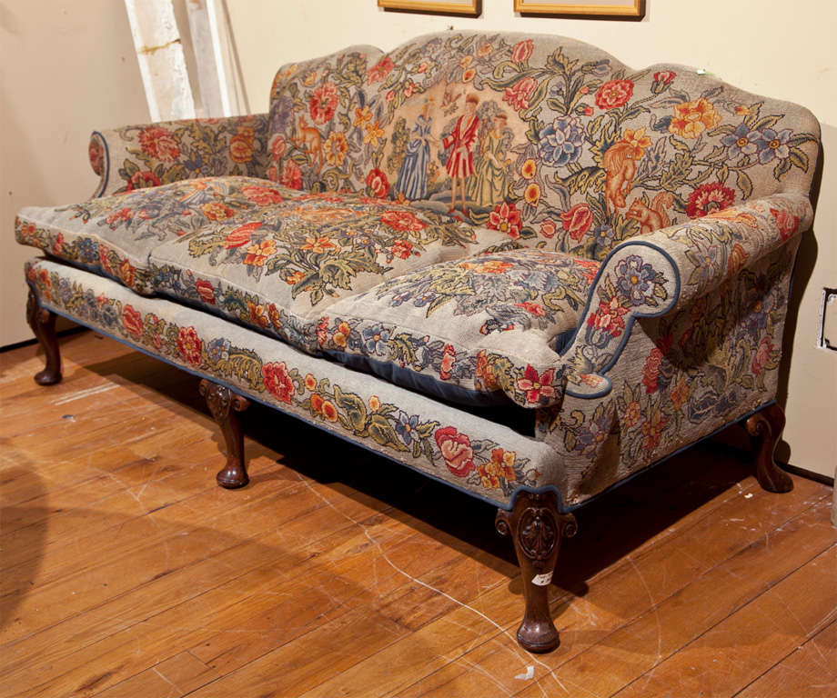 English Victorian style sofa, circa 1920s, beautiful walnut frame upholstered in needlepoint fabric, rolled arms, cushioned seat, raised on splayed legs ending in pad feet.