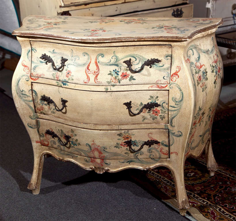 Attractive Italian Venetian style bombe chest of drawers, circa 1930s, overall distress ivory painted with hand-painted floral motifs, three drawers.