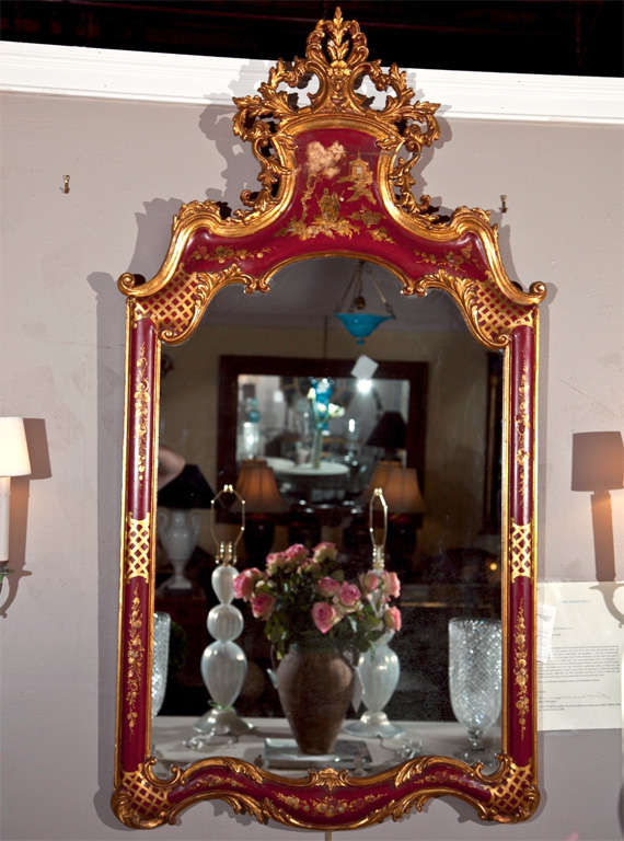 Unique French Rococo style mirror depicting a hand-painted chinoiserie scene, late 19th century, overall red painted and parcel-gilt, the top deocrated by elegant carving of foliate and scrolls. 

Letter of authentication provided by James Archer