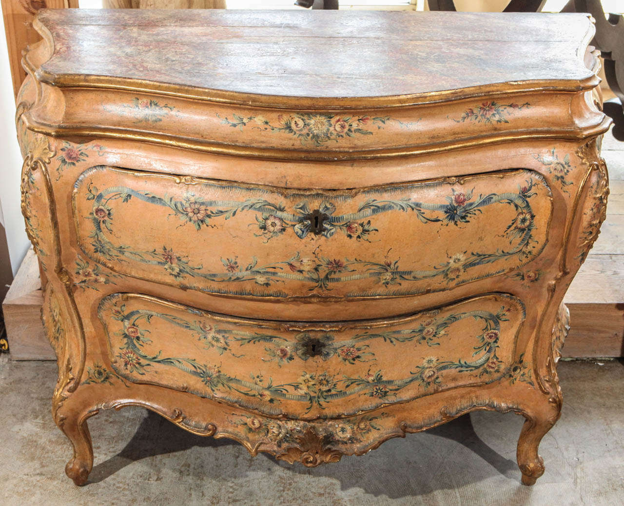 Hand-painted and carved, parcel-gilt, tangerine, two-drawer Bombay commode with faux marble top.