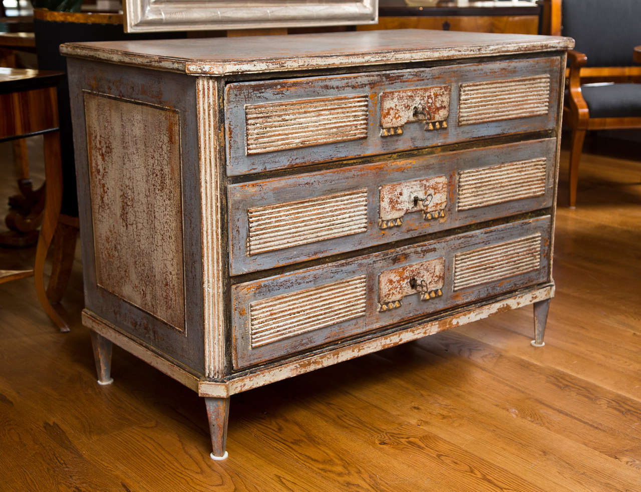 18th century painted Louis XVI Commode comprised of three drawers on angled tapered legs,  drawers adorned with reeded panels and oxidized gilt dental molding, painted in silver tones of grey blue and creme, Baltic, 1780 ca, paint refurbished