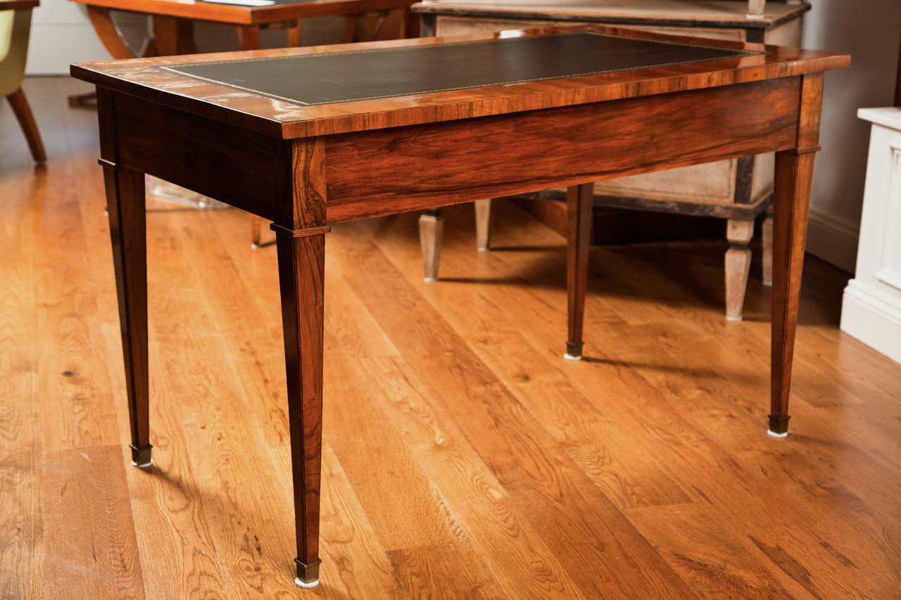 A generously sized walnut Bureau Plats with applied black leather inset tops complete with gold tooling, wood finished on all sides, the front containing two drawers and finishing on straight and tapered legs, Biedermeier, 1840ca