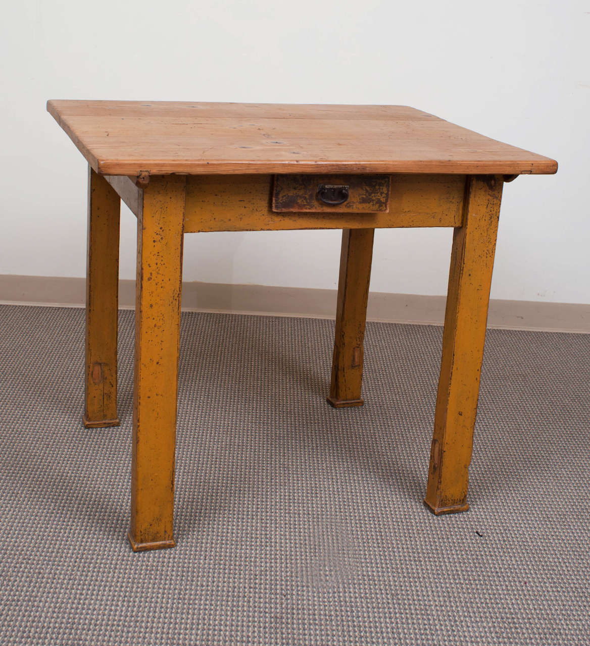 A small and very rustic table to add charm and character to any location.  The three board top is waxed to a rich warm brown and the base, on four straight legs, is in distressed mustard on barn red paint.  The front apron features a single central