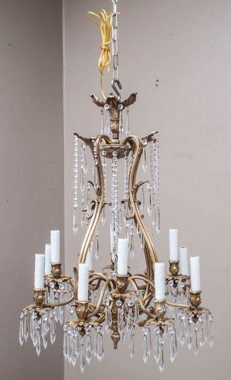 Unusual pear-shaped hand cast frame with lead crystal prisms, 12 lights. Appropriate ceiling cap, one foot of chain and hanging hardware included.