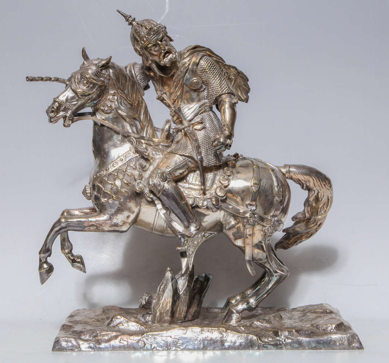 Pair of silvered bronze groups of equestrian fighting knights on horses. These groups capture the moment of tension before the knights cross weapons. The horses rear up on their hind legs and toss their heads while the knights heroically remain in
