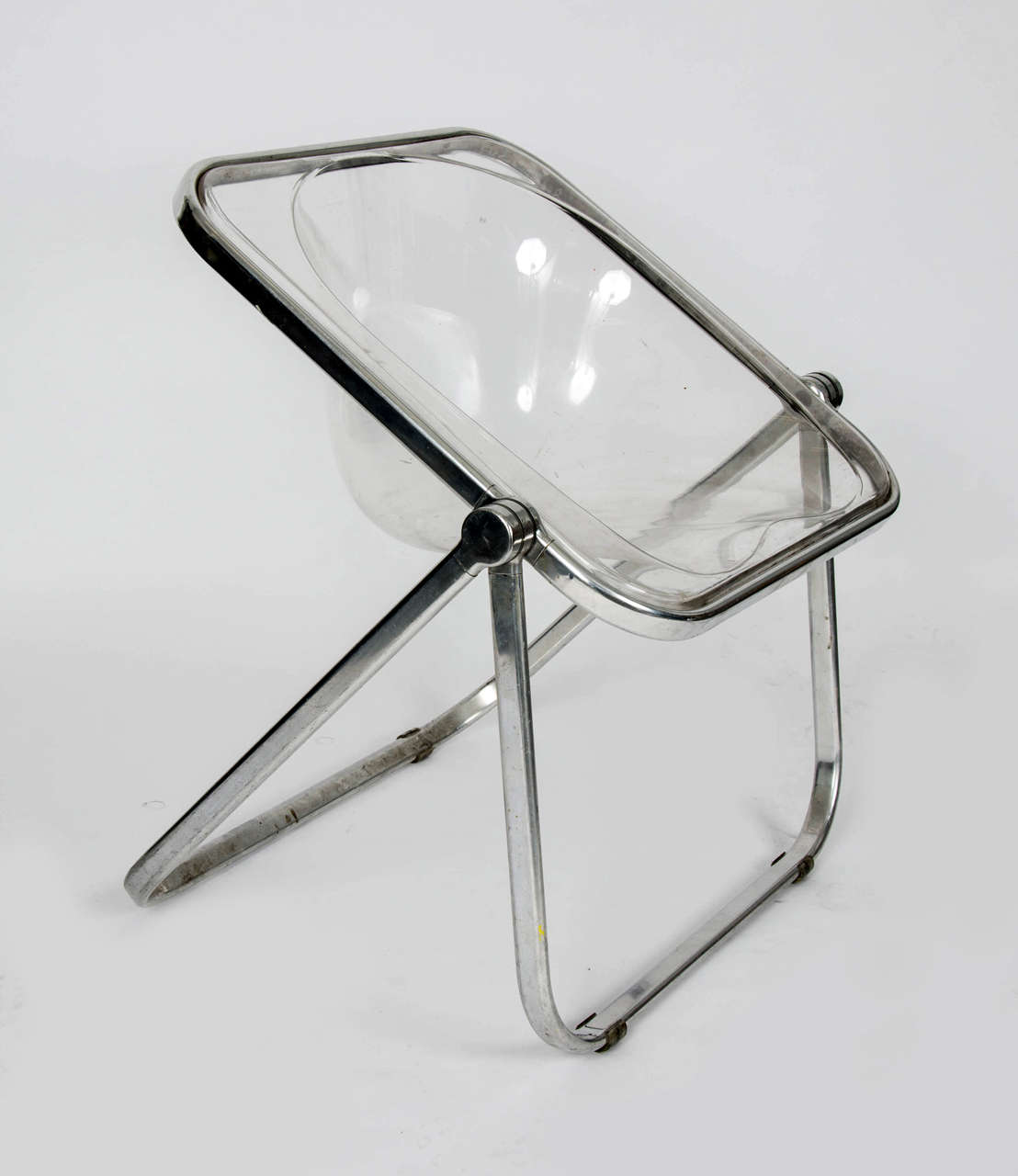 An original1969 'Plia' clear folding chair by Giancarlo Piretti for Castelli. This piece contains markings and scratches that are consistent with age and use.

By Giancarlo Piretti. 

