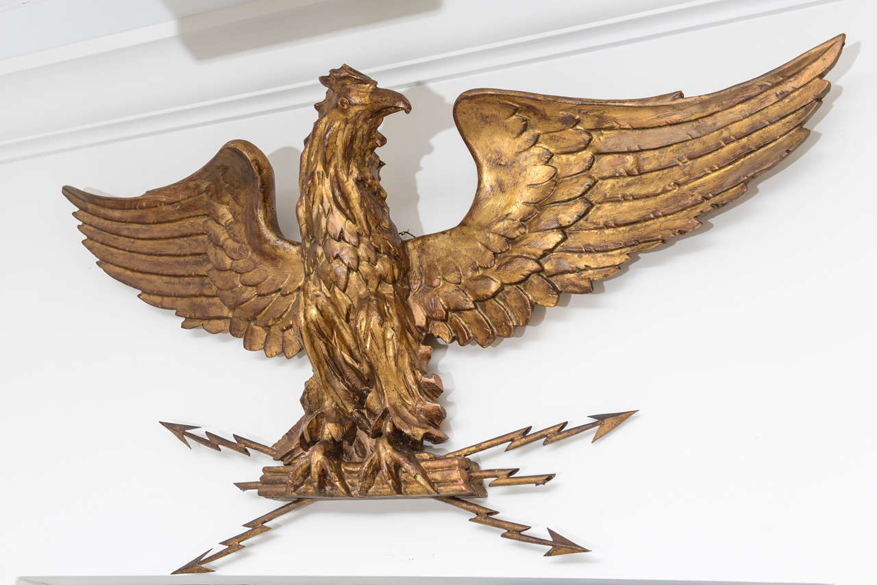 Beautiful detail in this gilded and carved eagle perched on crossed gilded metal lightning bolts.