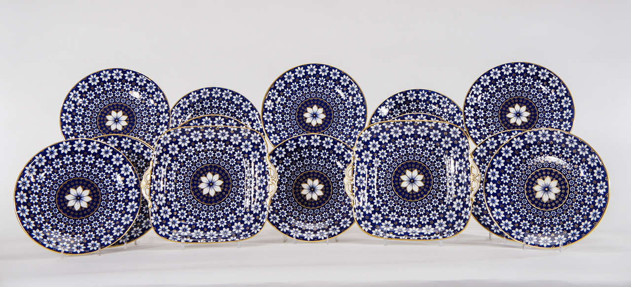 This set of 12 dessert plates and two matching square cake plates look as if they have never been used and are as modern looking as they are classical. The bold, graphic design is highlighted in gold depicting an all-over daisy motif. These