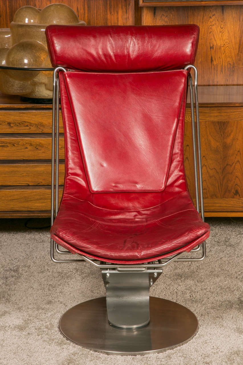 Pair of 'GRAND PRIX OF DANISH DESIGN IN 1991' stainless steel and red leather armchairs with integrated footrest. 

Two possible positions: sitting or semi-reclining. 

(Sitting: 55.5cm x 90cm H x 104cm) 
(Semi-reclining position: 55.5 cm H x