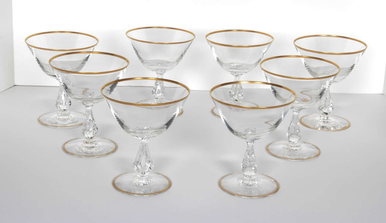 A set of four Mid-Century cocktail or champagne glasses with gold rim. Featuring beautifully articulated stem. Not dishwasher safe. Two sets available.