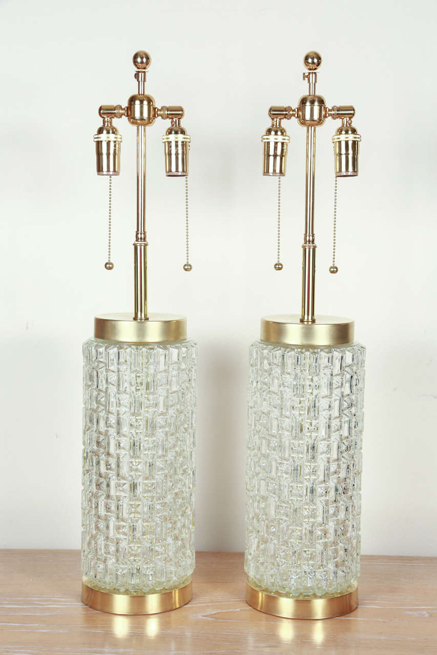 Lovely pair of table lamps with faceted glass mounted on brass bases.  They are newly rewired with brass double clusters