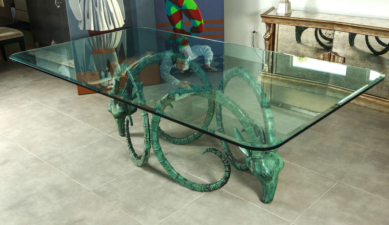 Stunning ibex head dining table in the style of Chevret. The two graceful ibex heads have a beautiful verdigris finish. The glass top has a wide bevel and curved corners and can accommodate 10 people easily
and 12 for those more intimate
Dinner