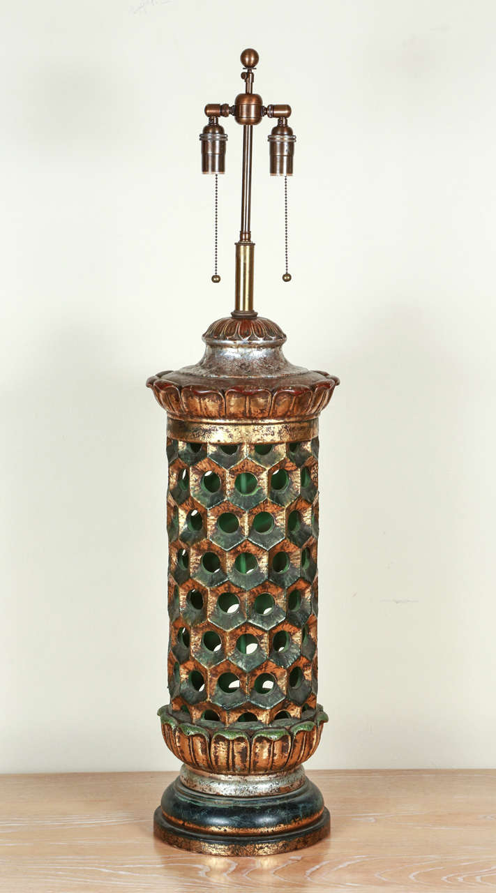 Very grand ceramic table lamp. The body of the lamp is pierced and the base and cap have vaguely lotus style moldings. The glaze is multicolored, with silver, gold and green, all beautifully muted, with a brown over-glaze giving the effect of a rich